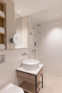韦斯特兰Wyn. Strandhotel Sylt的白色的浴室设有水槽和淋浴。