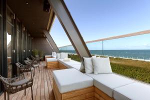 韦斯特兰Wyn. Strandhotel Sylt的阳台配有白色家具,享有海景。