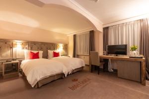 克莱恩 蒙塔纳Hotel Central, Spa & lounge bar的酒店客房配有一张床、一张书桌和一台电视。