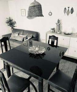São JoãoCasa Lilás的客厅配有一张黑桌子和椅子