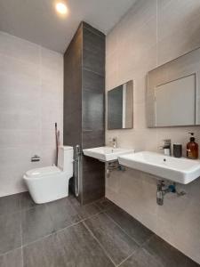 哥打巴鲁The Penthouse TROIKA KOTA BHARU的浴室配有2个盥洗盆、卫生间和浴缸。