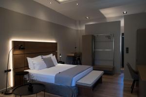 马科普隆ILION Air Host - near Athens International Airport的一间卧室配有一张床、一张桌子和一盏灯