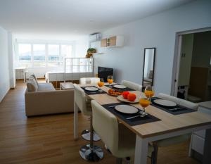 马拉加Sunstay - Seaview Guadalmar的用餐室以及带桌椅的起居室。