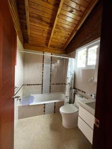 奥塔瓦洛Cabañas Tecla María的浴室配有卫生间、浴缸和水槽。