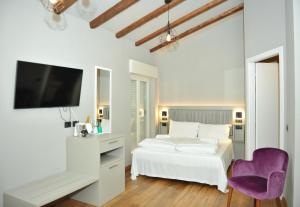 格拉多Ca’ Bruno Masaneta的白色卧室配有白色的床和紫色椅子