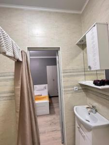 阿克托比Мини-гостиница Береке的一间带水槽的浴室和一间带床的房间