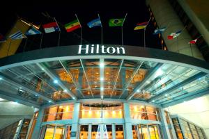 门多萨Hilton Mendoza的悬挂旗帜的建筑顶部的希尔森标志