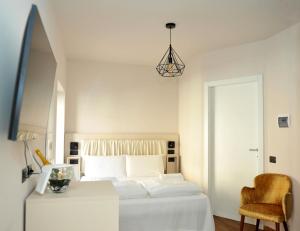 格拉多Ca’ Bruno Masaneta的白色卧室配有床和椅子