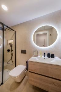 科洛尼亚圣霍尔迪Alma Libre Beach Apartment的一间带水槽、卫生间和镜子的浴室