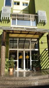 皮特什蒂利加塔酒店的前面有盆栽植物的绿色建筑