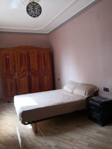 SelouaneFamily house 2 bedrooms, 2 sdb, near Center of Nador & Airport的一间卧室配有一张床和一个木制橱柜