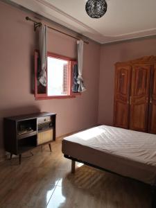 SelouaneFamily house 2 bedrooms, 2 sdb, near Center of Nador & Airport的一间卧室配有一张床、一个梳妆台和一扇窗户。