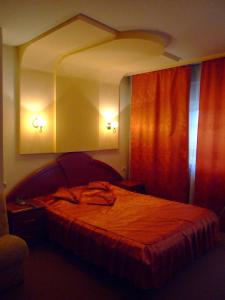 皮特什蒂利加塔酒店的一间卧室配有一张带红色窗帘的大床