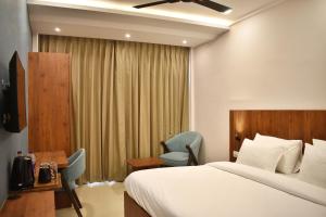 哈里瓦Arjun - A boutique hotel的酒店客房带一张床、一张桌子和椅子
