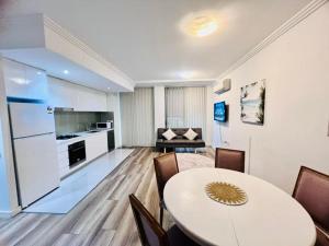 悉尼Apartment in Turrella的一间带桌子的客厅和一间厨房