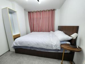 首尔LaonHajae的一间小卧室,配有一张床和一张带台灯的桌子
