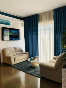 梅斯特圣卡罗酒店的客厅配有两张沙发和一台电视机