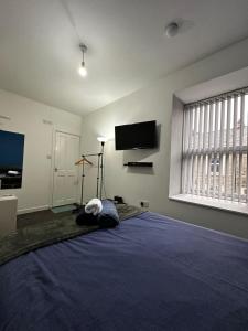 阿克灵顿Blackwood Residence的一间卧室设有一张大蓝色的床和一台平面电视