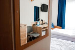 弗瓦迪斯瓦沃沃Hotel Kliper的一间卧室配有一张床、一把椅子和镜子