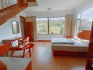 科代卡纳尔RS Family Stay的配有一张床、一张书桌和一扇窗户的酒店客房