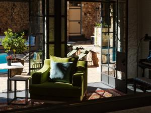 雅典Not Hotel的客厅配有绿色椅子和桌子