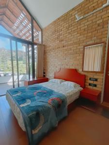 科代卡纳尔RS Family Stay的一间卧室设有一张大床和砖墙