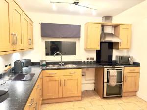 伍斯特Rooms Near Me - Worcester, Sky Tv, Free Double Parking的厨房配有木制橱柜和炉灶烤箱。