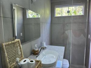 巴西利亚Casa da 17 - Lago Sul的一间带水槽、卫生间和镜子的浴室