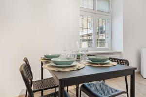 布拉迪斯拉发City Center Suite - Modern & Stylish的餐桌,配有四碗和椅子