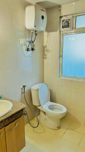 诺伊达Palm Studio & looms的一间带卫生间、水槽和窗户的浴室