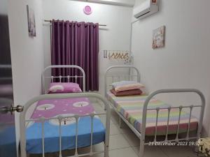 甘榜龙溪İmpiana Homestay near PUTRAJAYA, CYBERJAYA, Musliem Only,WIFI,Netflix的紫色窗帘间内的两张床