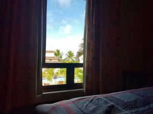 皮帕Chale Maria Em Praia Da Pipa!!!的卧室窗户享有棕榈树的景致