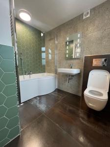 GreatstoneAmber Lights Coastal Getaway, Greatstone的带浴缸、卫生间和盥洗盆的浴室