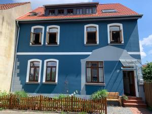 策勒Gästehaus EinsA的蓝色房子,有红色屋顶