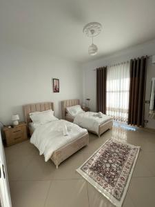 培拉特Harmony Villa Berat的一间带两张床的卧室和地毯