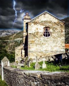 BigornoNuits magiques au village entre mer et montagnes的一座有天空闪电的古老教堂