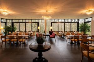 巴特尚道STEIGER Parkhotel Hohnstein的用餐室设有桌椅和窗户。