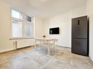 杜伊斯堡RAJ Living - 3 Zimmer Wohnung - 25 Min zur Messe DUS的一间带桌子和冰箱的用餐室