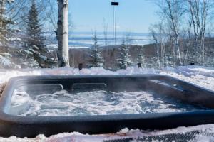 拜圣保罗Nørdika Charlevoix的院子里的热水浴池,被雪覆盖