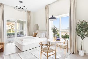 阿布扎比Silkhaus Sea View studio in Marina Rise Tower的白色的客厅配有床和桌子