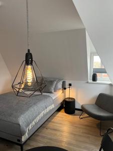 布克斯泰胡德Studiowohnung 6 in Buxtehude的一间卧室配有一张床和一把椅子