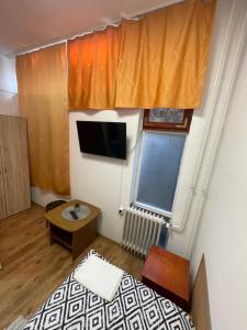 多瑙新城Álom Vendèghàz的小房间设有床和电视