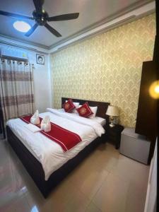 琅勃拉邦Xuan Keo place house 2的一间卧室配有一张带红色枕头的大床