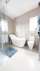 贝尔法斯特Charming Character House in Beautiful Neighborhood的白色的浴室设有浴缸和卫生间。