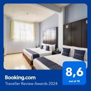 科阿特佩克Hotel Spa Shalam的酒店客房,设有两张带蓝色墙壁的床