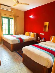 索拉哈Horizon Homes - Sauraha Chitwan的红色墙壁客房的两张床