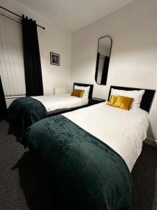 利物浦Anfield end terraced home的配有衬衫的酒店客房内的两张床