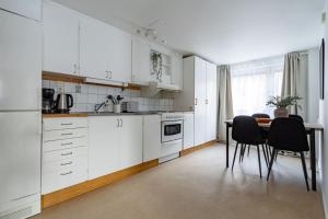 斯德哥尔摩Sodermalm Hideaway Haven的厨房配有白色橱柜和桌椅