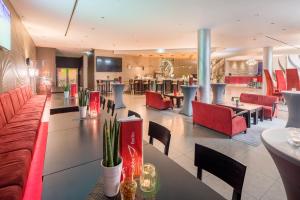 柏林柏灵阿巴巴酒店的大堂内的餐厅,配有红色的椅子和桌子