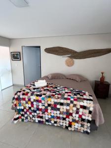 巴拉-杜加萨斯Pousada Encantos do Roncador的一间卧室配有一张带彩色毯子的床